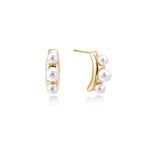 14K gold-plated curved stud earrings with three white freshwater pearls aligned vertically on cream background